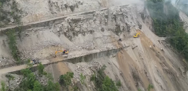 Excavators clear landslide debris from a road in Moxi County after Luding earthquake.