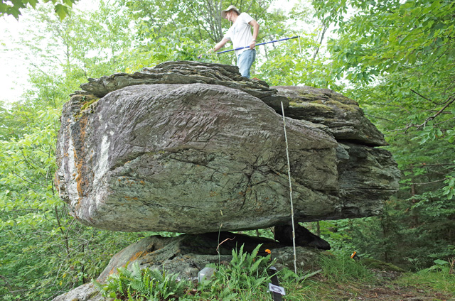 precariously balanced rock in Westfield, Vermont, with Tom Pratt standing on top