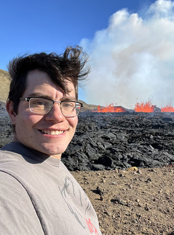 Julian Lozos stands in front of lava from the 2022 Meradalir eruption in Iceland." width="500" height="677" /> Lozos at the 2022 Meradalir eruption in Iceland.